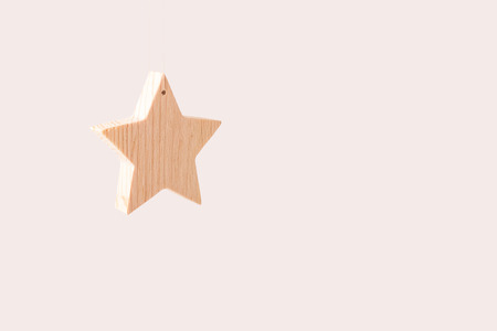 Wooden star as xmas decoration isolated on light background. Free space for text on the right.の写真素材