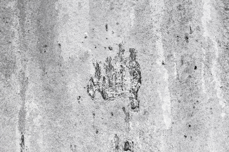 Wall with chipped and notched cement and concrete. Visible smudges and dirty surface. Many hollows and roughness.の写真素材