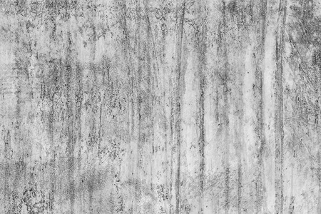 Wall with chipped and notched cement and concrete. Visible smudges and dirty surface. Many hollows and roughness.の写真素材