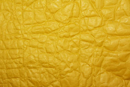 Parcel envelope. Crumpled yellow paper texture. Top view, horizontal layout. Yellow postal cardboard package. Copy space on the package. Uniform wrinkled yellowed paper.の写真素材