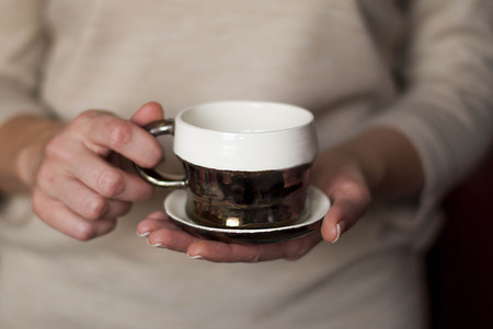 Female hands holding a cup of coffeeの写真素材