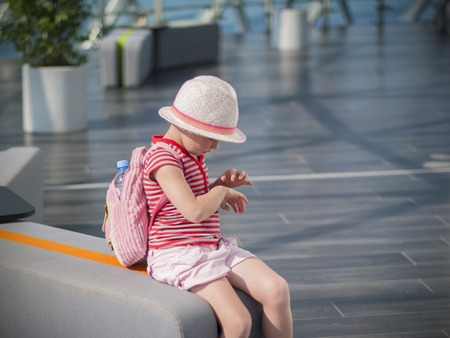 The girl is waiting for transport at the station, the plane at the airport.の写真素材