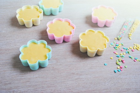 Rows of colorful cups. Muffins preparation at home. Ingredients for baking at home. Valentine day or mother day, easter, wooden background. Muffin products.の写真素材