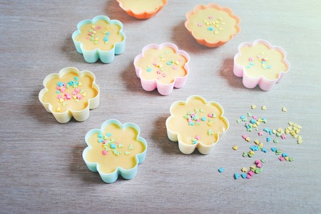 Rows of colorful cups. Muffins preparation at home. Ingredients for baking at home. Valentine day or mother day, easter, wooden background. Muffin products.の写真素材
