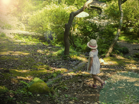 Japanese Garden in the Botanical Garden in Batumi, Georgia. Magic Botanical Garden. girl in a white dress and hat walks in the garden, soft sunshine.の写真素材