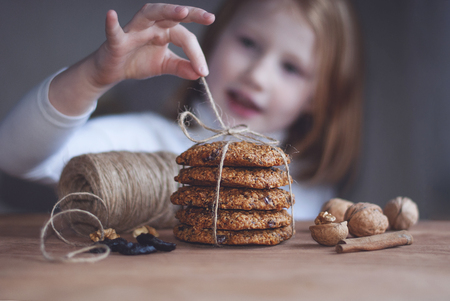Brown still life, handemade oatmeal cookies, hands near cookies, the girl in the background.の写真素材