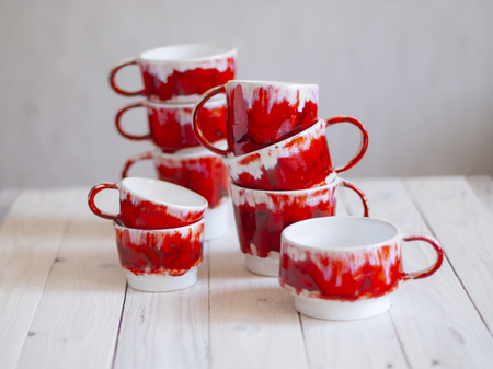 set of red mugs on a wooden table, for tea or coffee. The interior of the cafe. Waiting for guests. Home decor.の写真素材