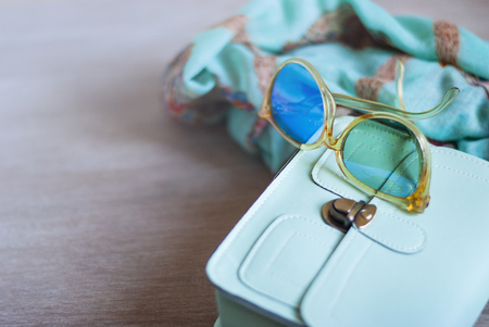 Fashionable photo bright handbag, scarf, big retro glasses, colorful beads. Place to signの写真素材