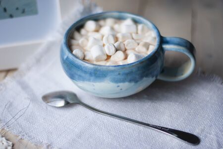 A cup of cacao with marshmellows and christmas decoration on the table with colorful background. Chistmas holiday background. Phantom Blue.の写真素材