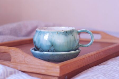 Breakfast in the bed. Big cup of tea on a tray. Comfort of home atmosphere.の写真素材