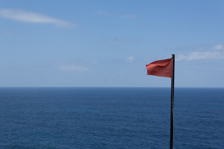 Red flag / beach ocean horizon - warningの写真素材