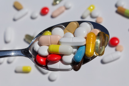 Spoon pills / capsules / medicine - close up - medical backgroundの写真素材