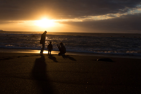 Parents and child - family silhouette sunset -Beachの写真素材
