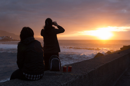 Beach / ocean sunset / sunrise - Tourist taking pictureの写真素材
