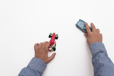 child hands isolated playing with cars on white backgroundの写真素材