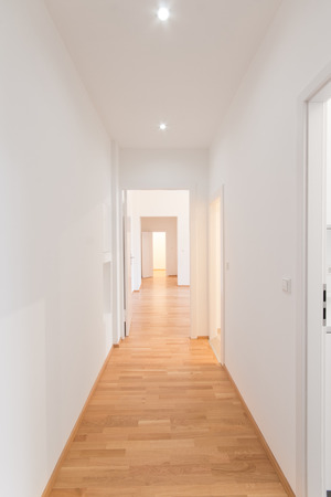 fresh renovated flat corridor, white walls, wooden floor.の写真素材