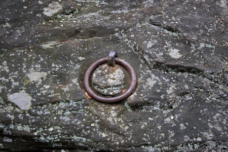old mooring ring, rusted metal ring on stoneの写真素材