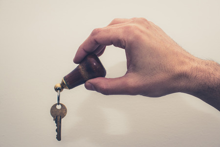hand holding hotel key on white background , vintage filter effectの写真素材