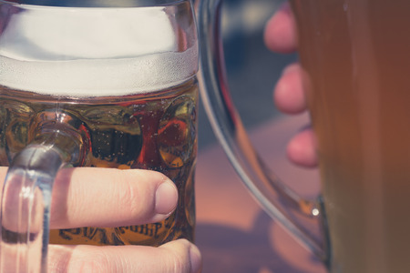 drinking beer in beer garden concept - clink glasses closeupの写真素材