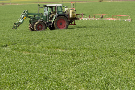 tractor spraying green field - agriculture backgroundの写真素材