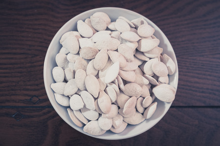 salted pumkin seeds in a bowl  on wooden tableの写真素材