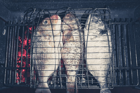 fish on barbecue grill - three fishes on fire