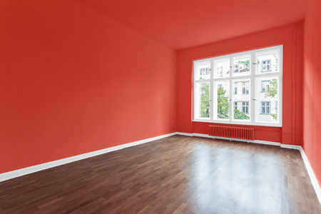 empty room with red walls and wooden floor の写真素材