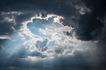 sun rays shining through dark cloud  sky -の写真素材
