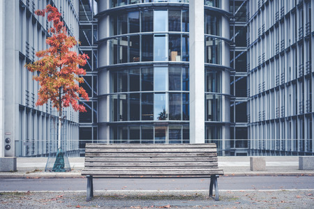 empty wooden bench outside modern office building -