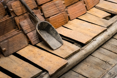 construction industry concept, old roofing tile and shovel on wooden floor の写真素材