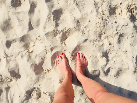 female legs and feet on beach - summer vacation concept -の写真素材