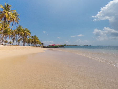 man and boats at beach with palm treesの写真素材