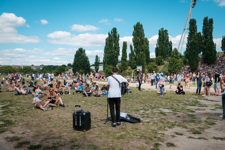 Musicians singing and playing guitar in crowded park on a sunny summer day in Berlin, Germanyのeditorial素材