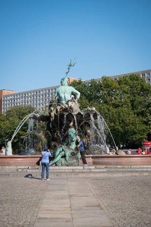 Tourist couple taking picture at Neptune Fountain at Alexanderplatz in Berlin, Germanyのeditorial素材