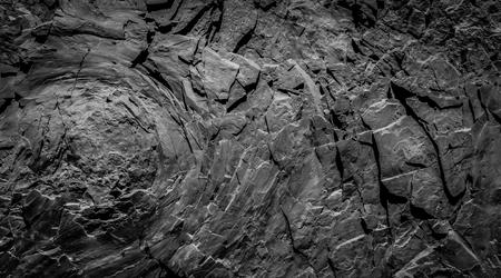 dark rock wall background - stone texture with onion skin weathering -