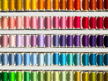 Sewing threads multicolored background closeup - fashion design