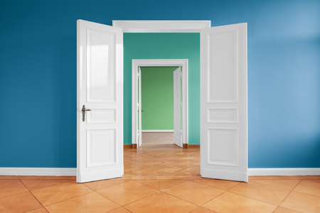 Open doors in empty apartment with colored wallsの写真素材
