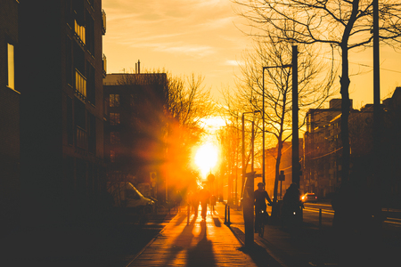 silhouette of people on bicycle and pedestrians on sidewalk during sunset -の写真素材