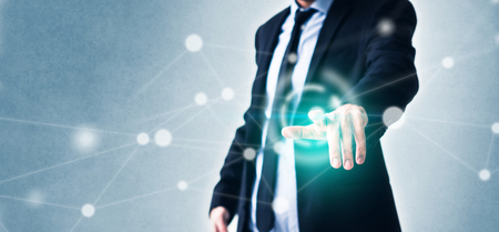 Man pointing finger on virtual screen with technology in business concept and glowing networkの写真素材