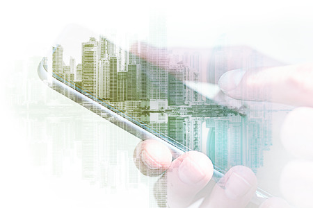 holding mobile phone / smartphone with city skyline double exposure,