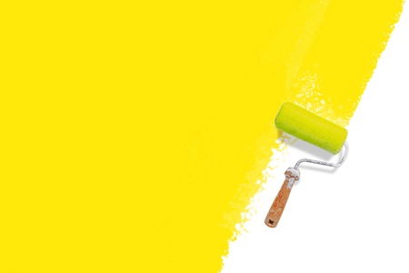 roller brush with painted yellow wall - colorful renovation conceptの写真素材
