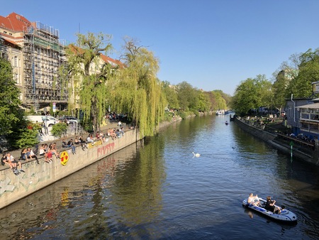 People enjoying sunny weather on the street, sitting at riverside in Berlin, Kreuzberg during springの写真素材