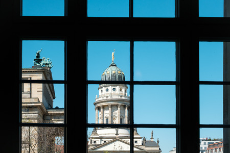 Window view on historic French Cathedral / Dome at Gendarmenmarkt, Berlin -