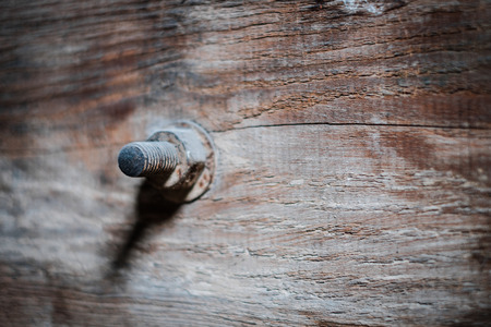 rusty screw in vintage wood closeup - construction concept background -の写真素材