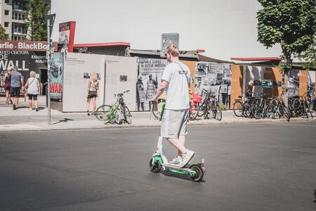Young man riding electric scooter, escooter or e-scooter on street in Berlin, Germany