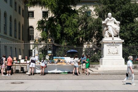People looking at second hand book on sale at flea market in front of Humboldt University in Berlin, Germanyのeditorial素材
