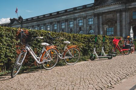 Electric E scooter, escooter or e-scooter and bike sharing bicycle on sidewalk in Berlinのeditorial素材