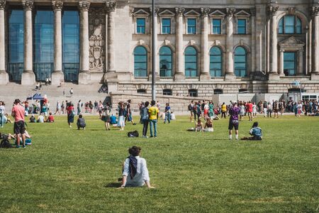 Many people on meadow in public park in front of the Reichstag building on a sunny, summer dayのeditorial素材