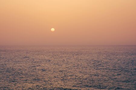 sunset on water, sun going down behind ocean -の写真素材