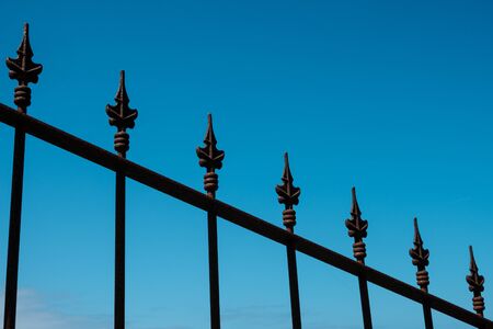 wrought iron spikes on fence  isolated on sky - railheadsの写真素材
